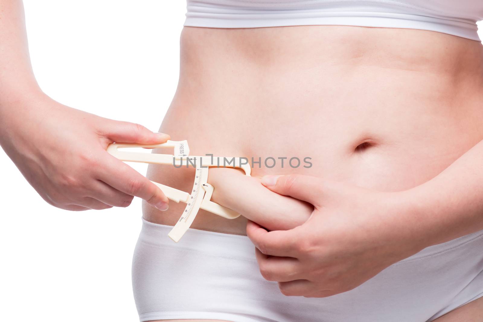 overweight woman measures the thickness of fat on the abdomen with the instrument