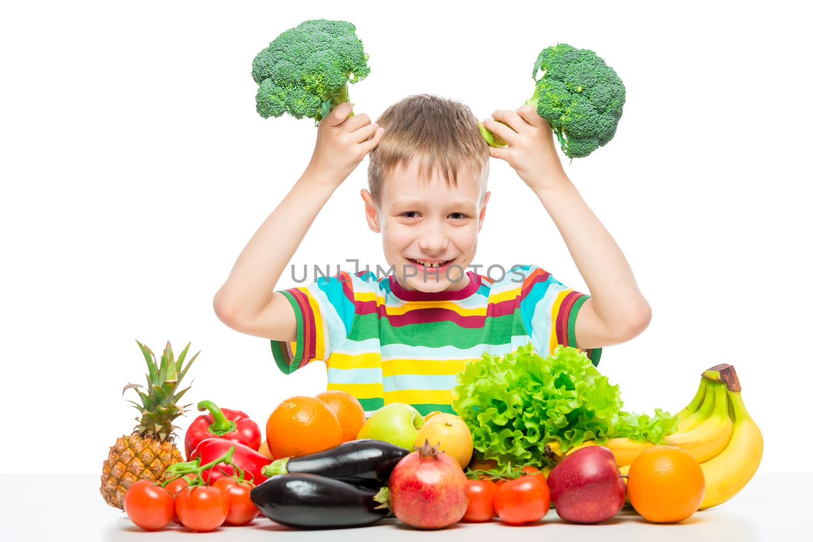 Boy playing with broccoli at the table with a bunch of vegetable by kosmsos111