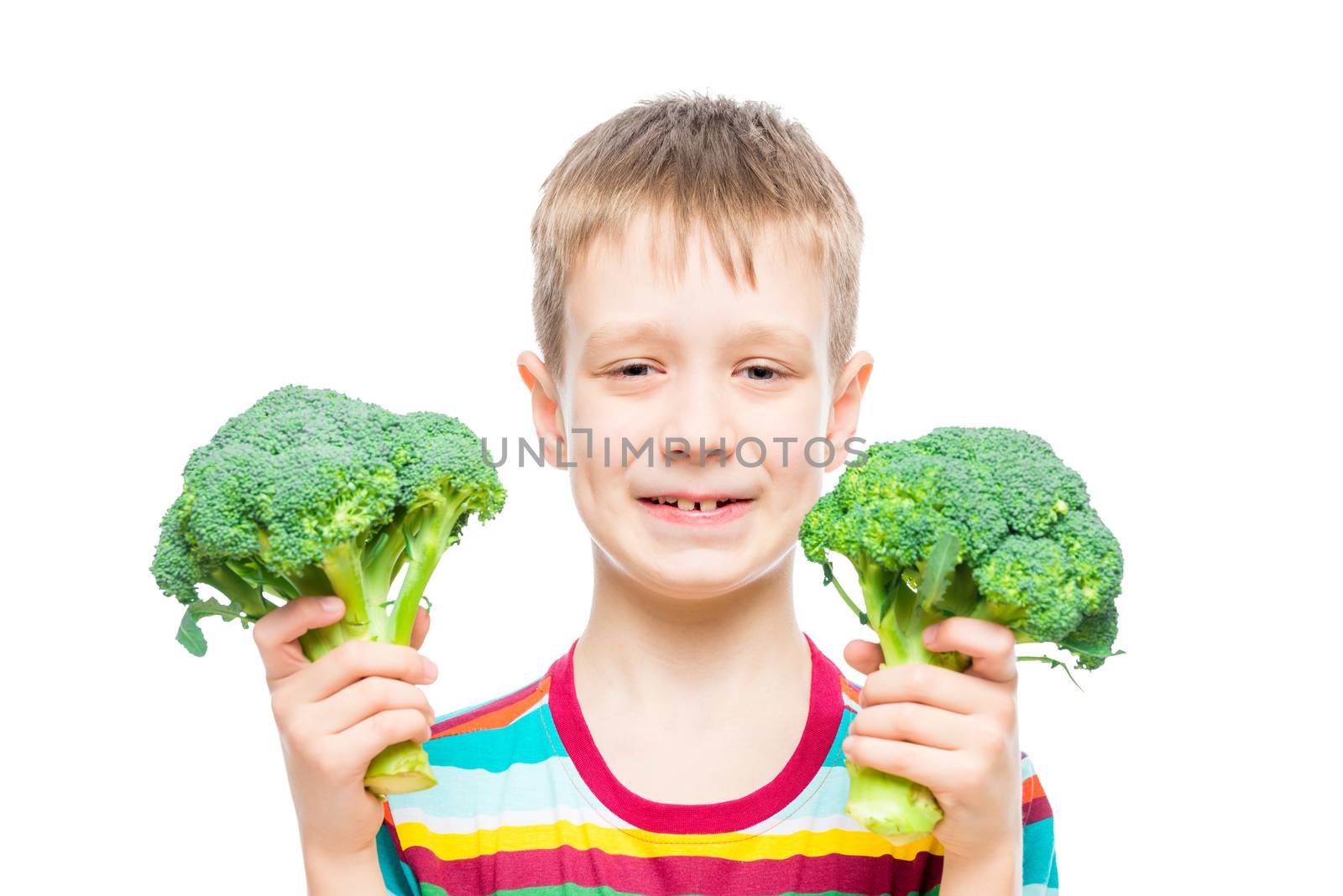portrait of a boy with broccoli in hands on white background in studio