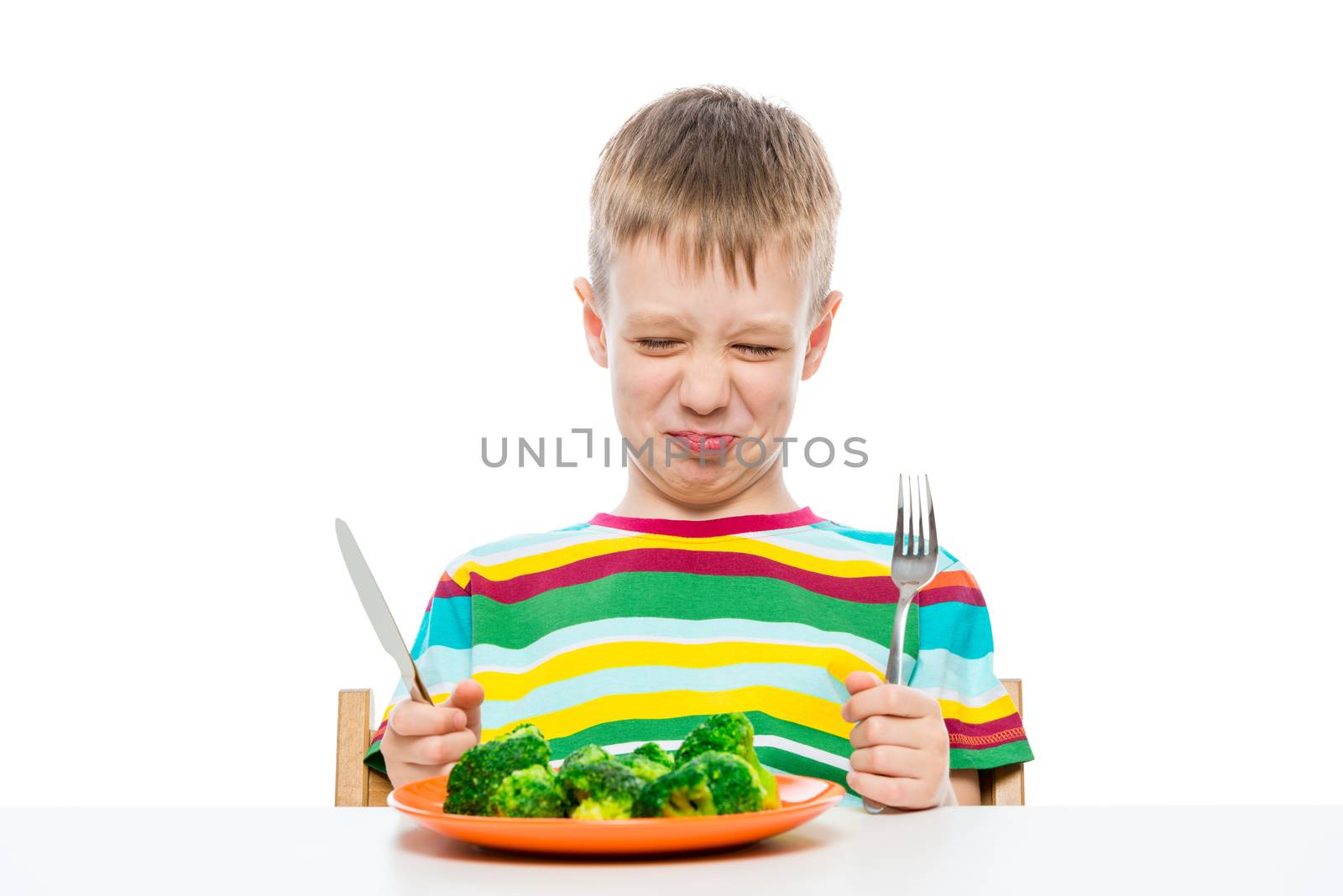 Grimace of a boy who does not like broccoli, portrait on a white by kosmsos111