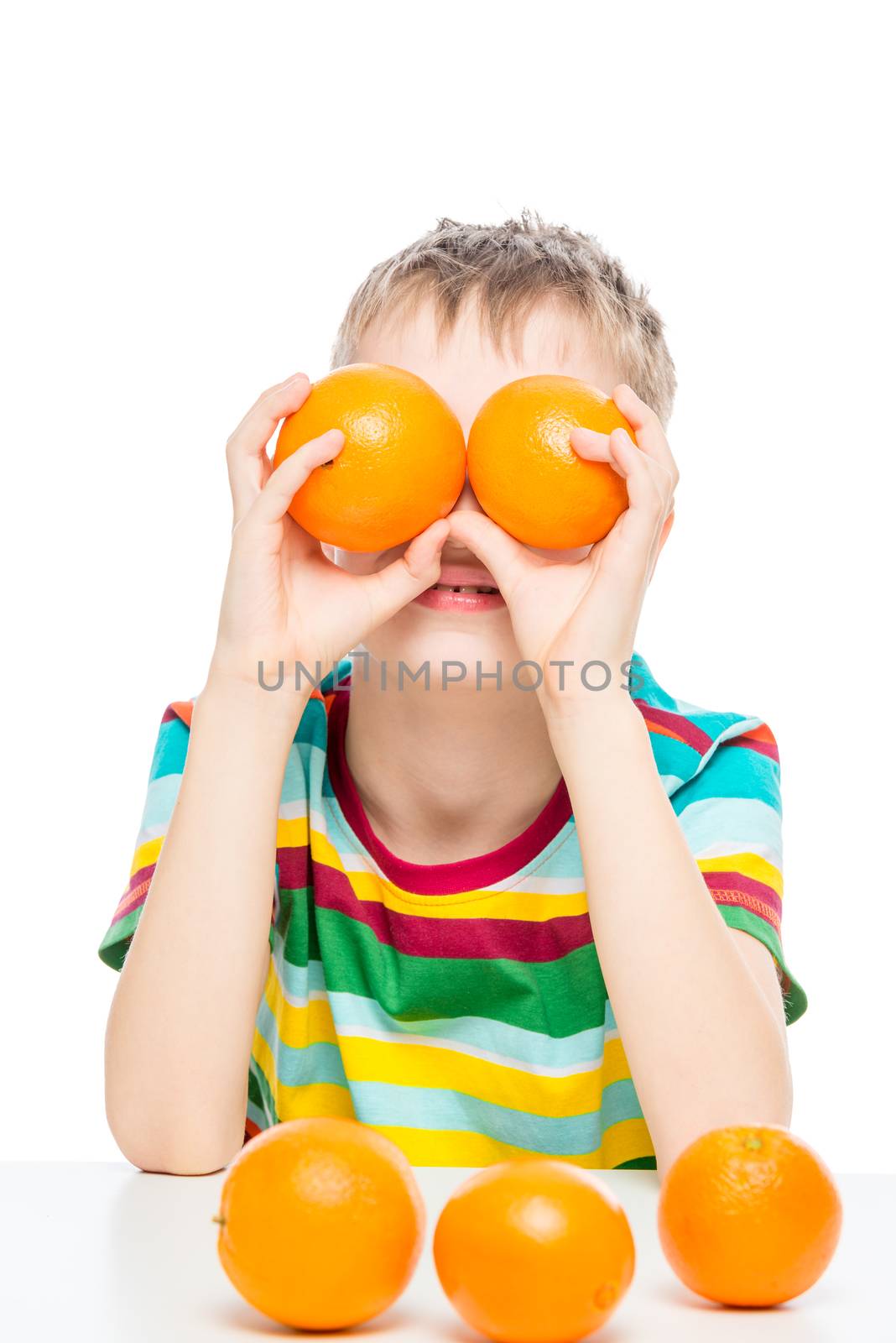 portrait of a boy who plays with oranges, shot in the studio on a white background
