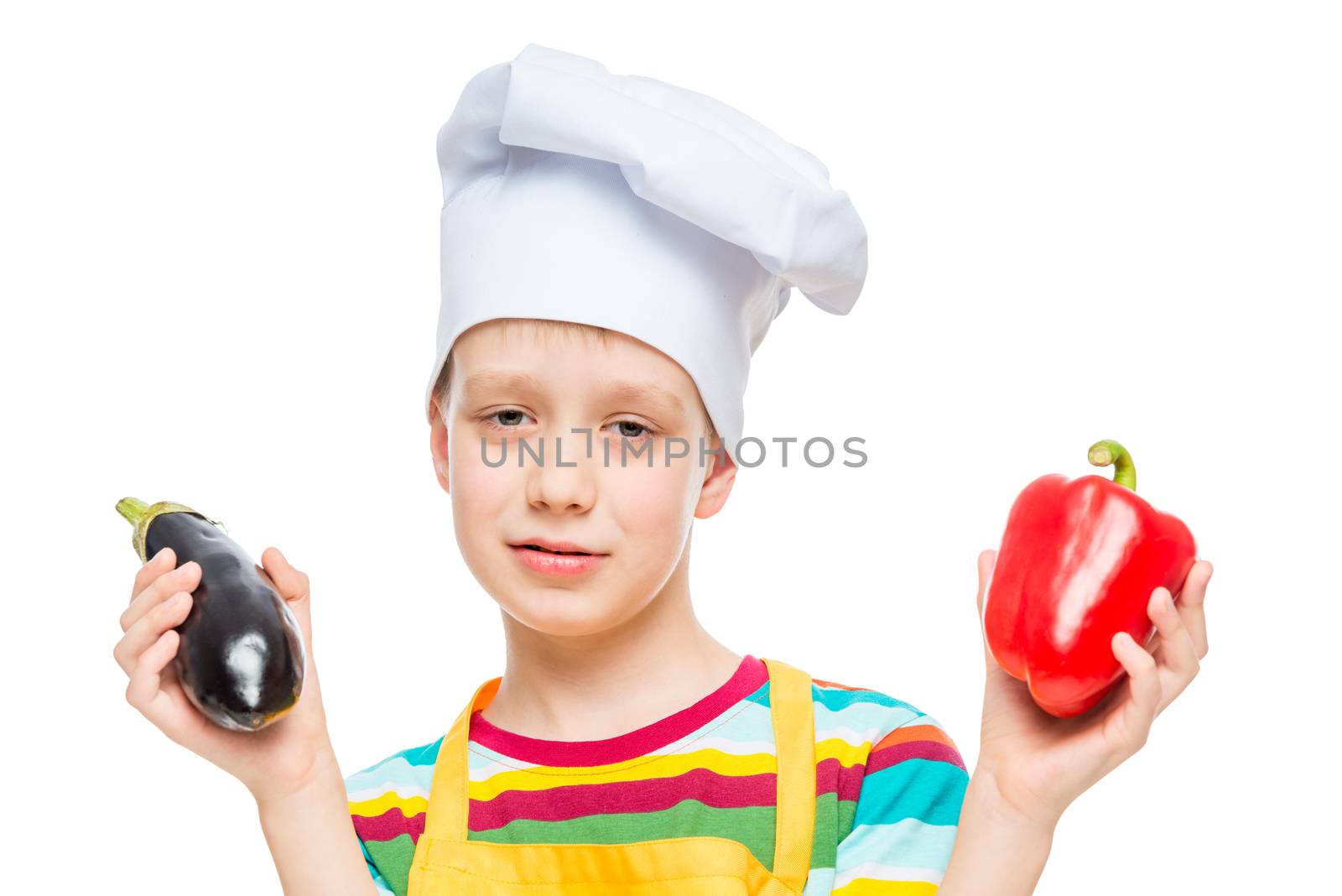 portrait of a child in a cook hat with pepper and eggplant on a white background