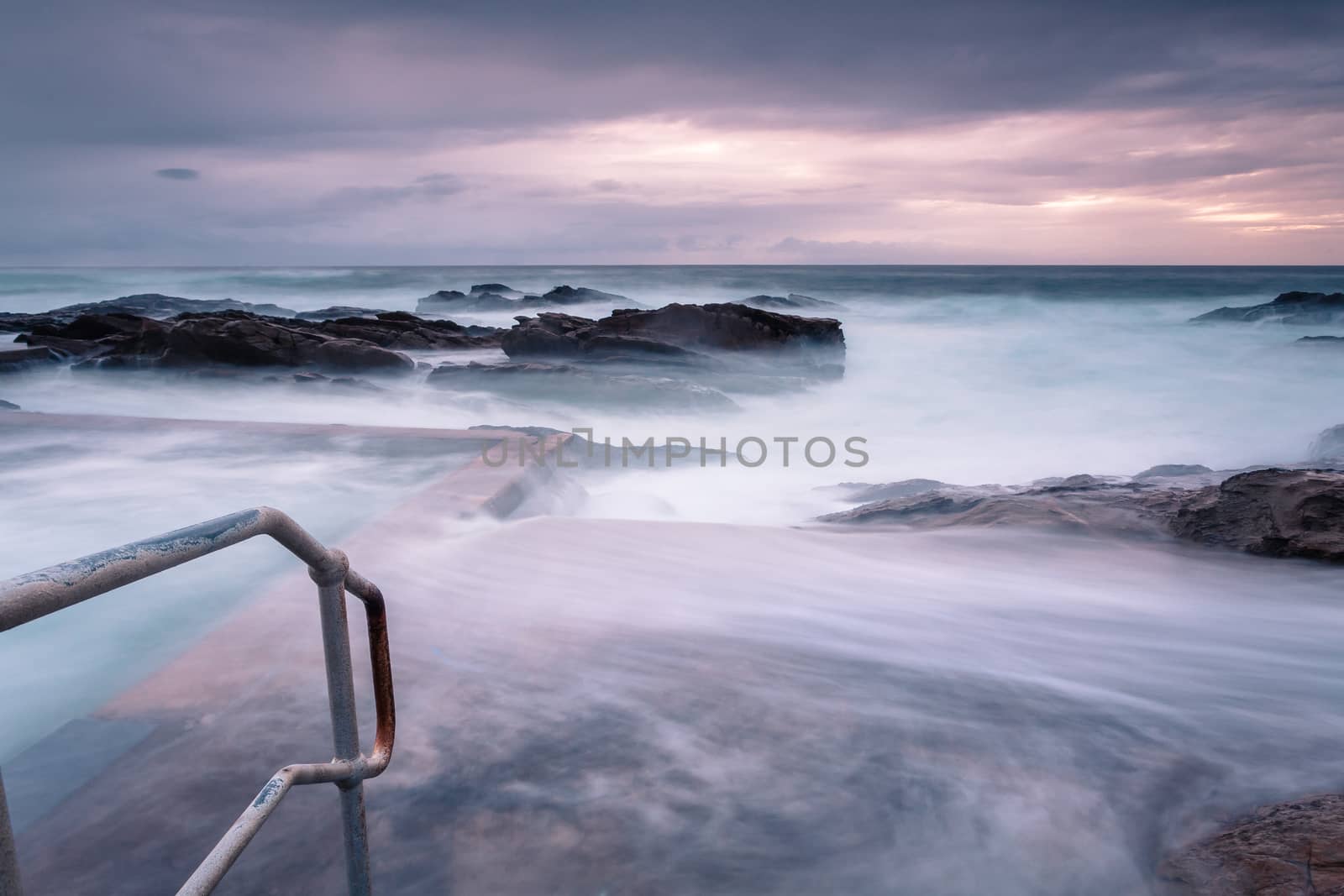 Large waves and swell engulf the public rock pool.  Long exposure  creates a mystical feel of what was a tempestuous ocean