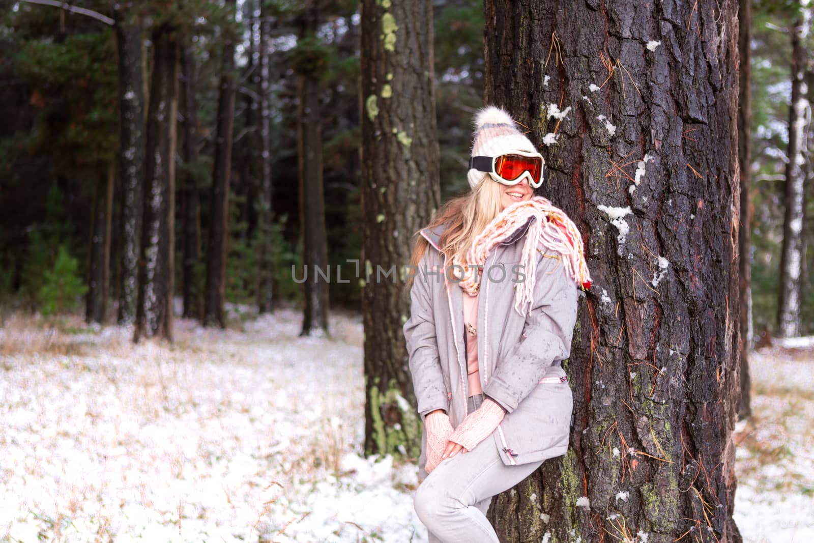 Woman leans against a tree in a snowy woodland of pine trees by lovleah