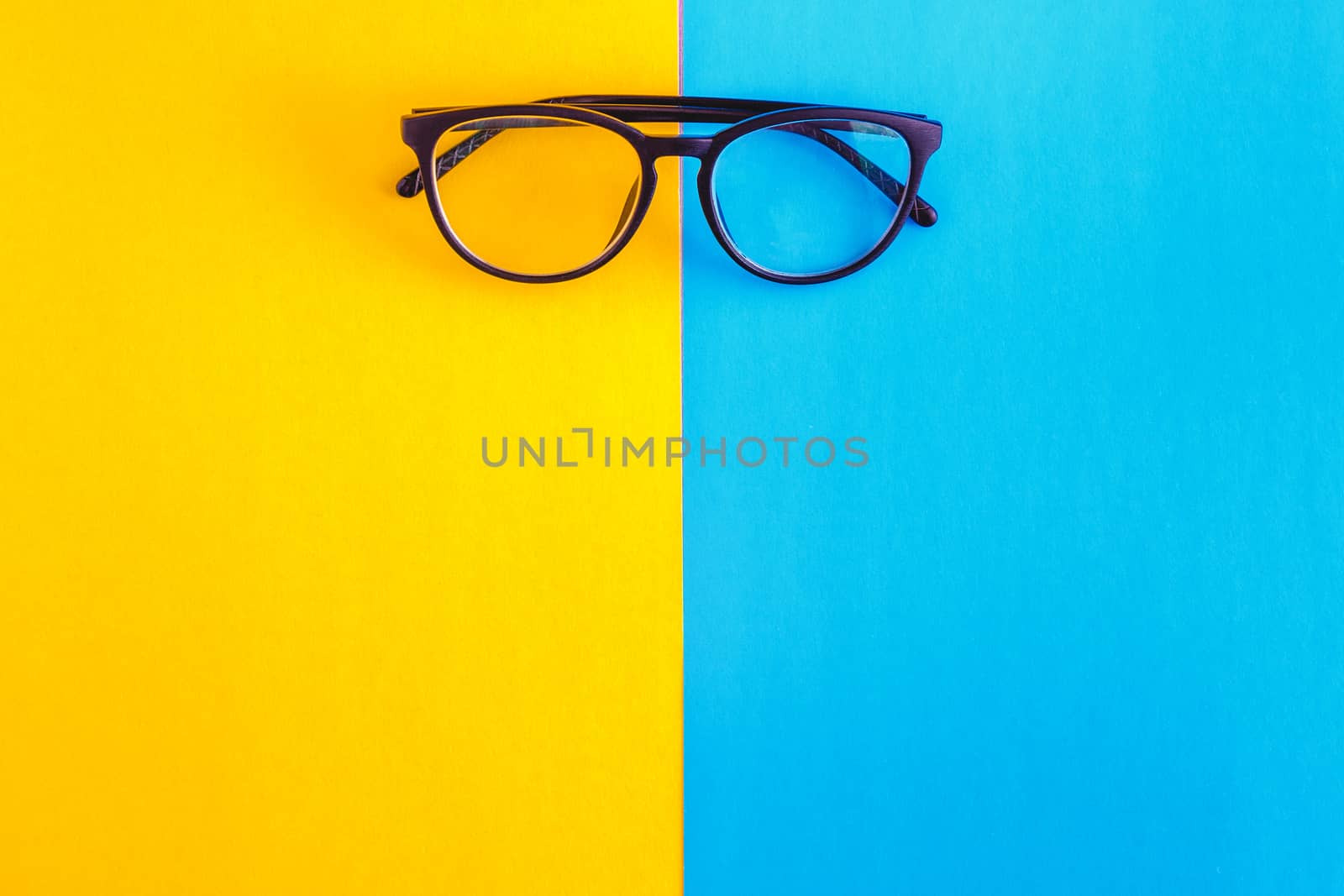 stylish glasses on a bright blue-cyan and yellow-orange backgrou by Tanacha