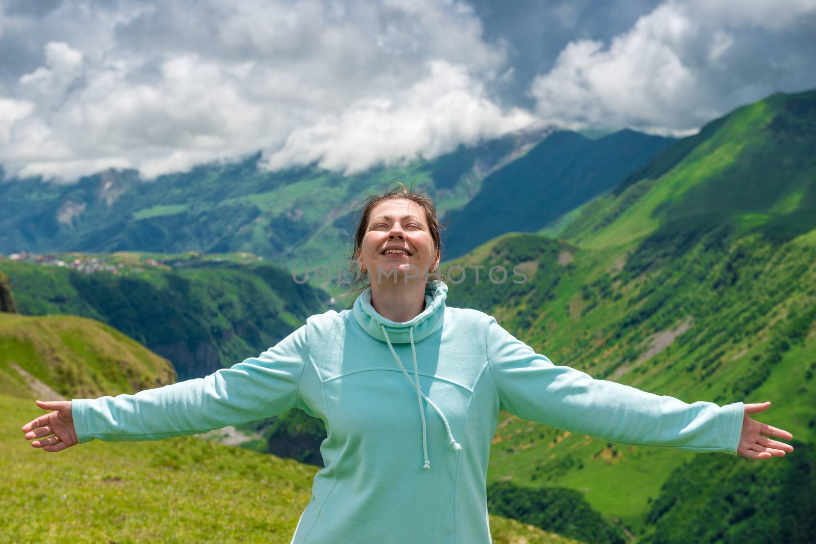 Happy woman enjoys the freedom to travel in the mountains