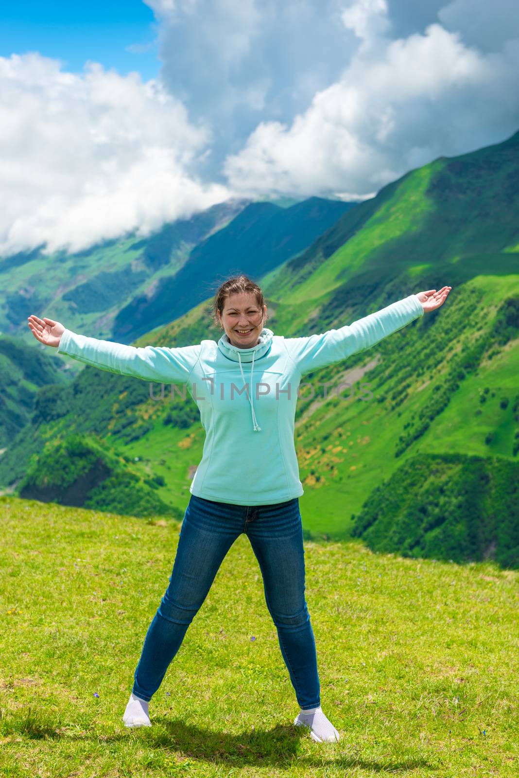 Woman in the mountains with arms spread to the sides with happy by kosmsos111