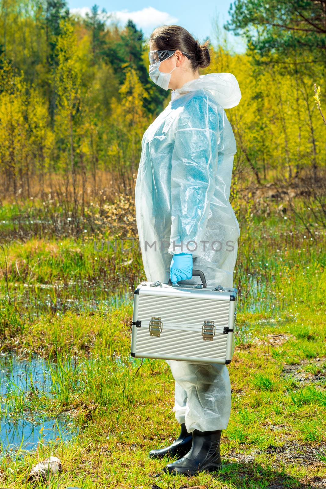 ecologist in overalls on the lake with equipment for taking water samples