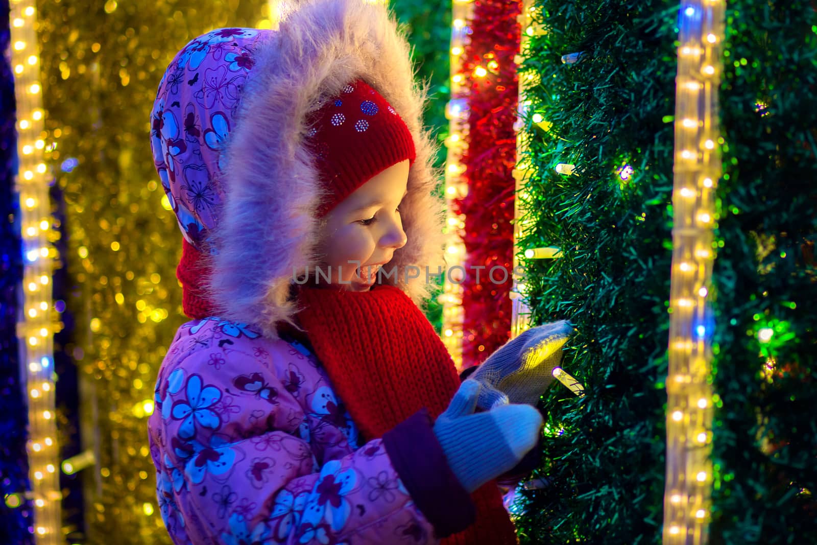 The girl watches Christmas fires in decoration of the city