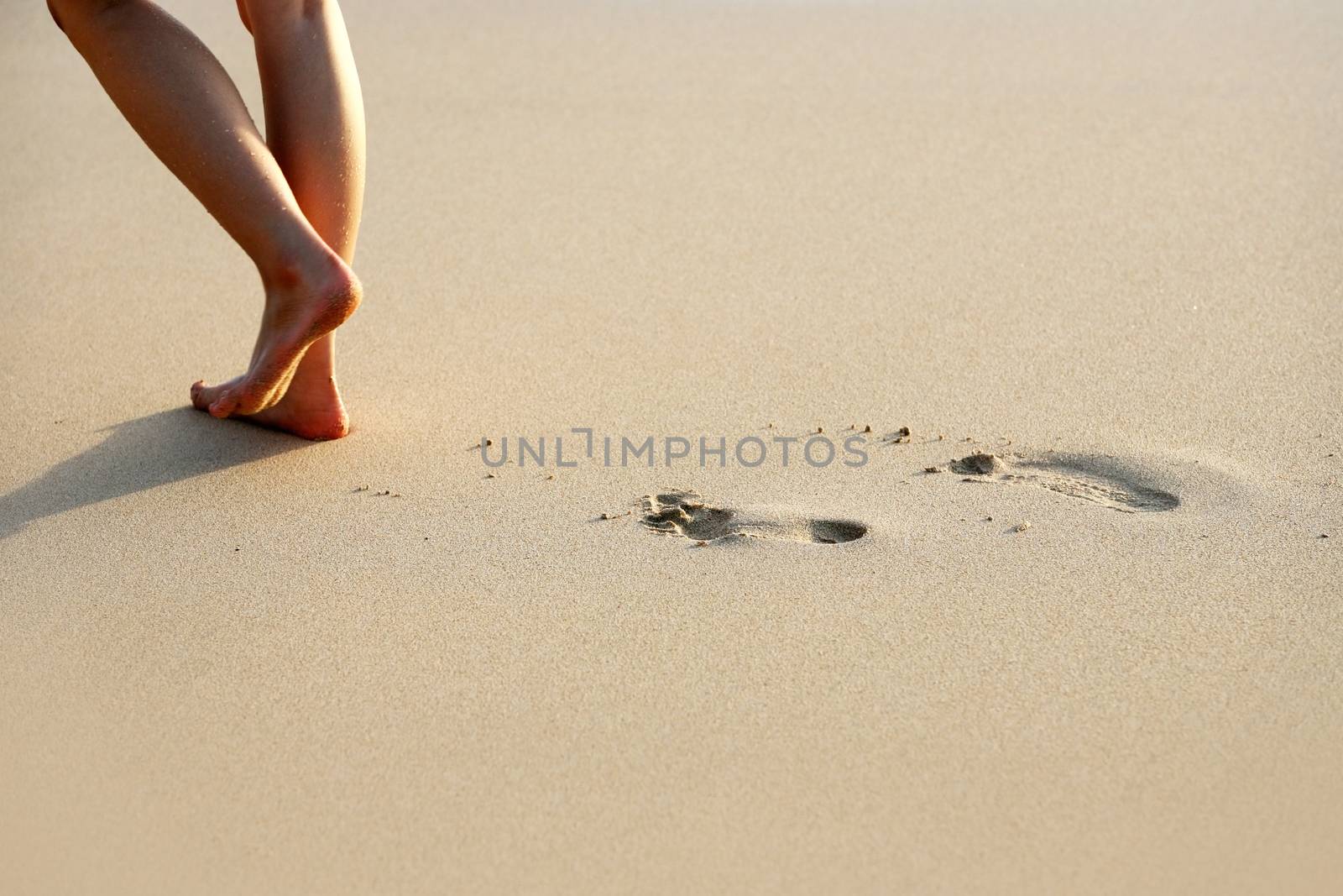 Female feet going on an ocean beach