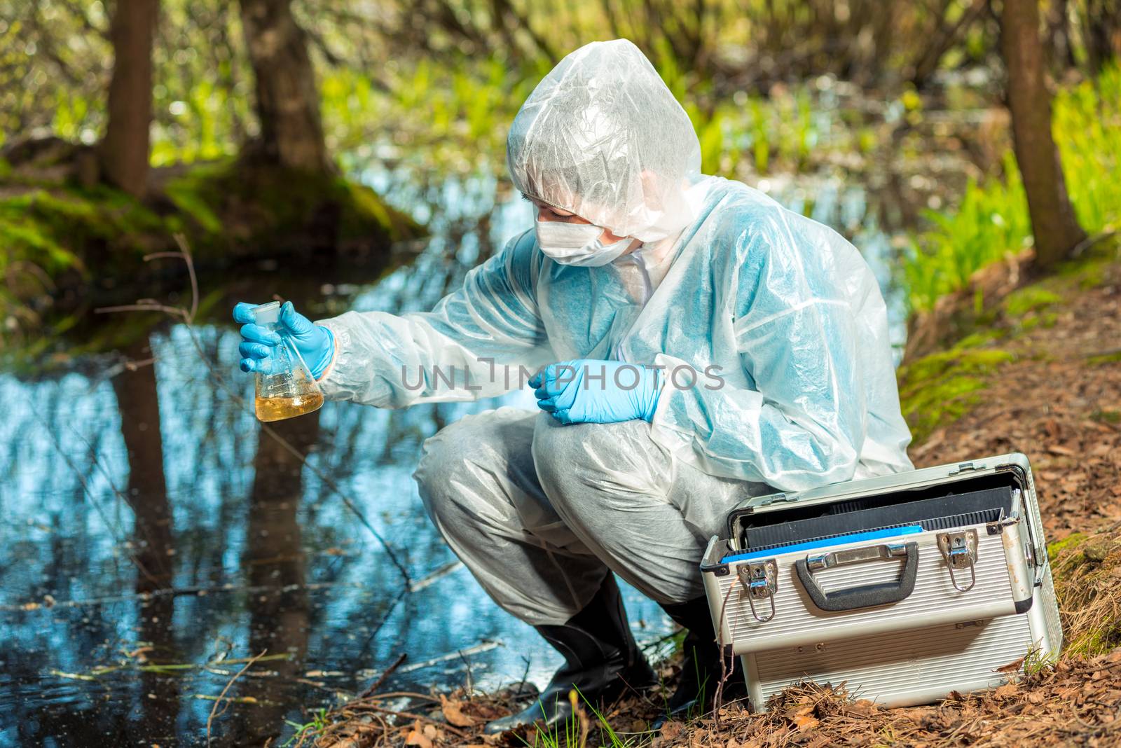 water sampling by an experienced ecologist from a forest river