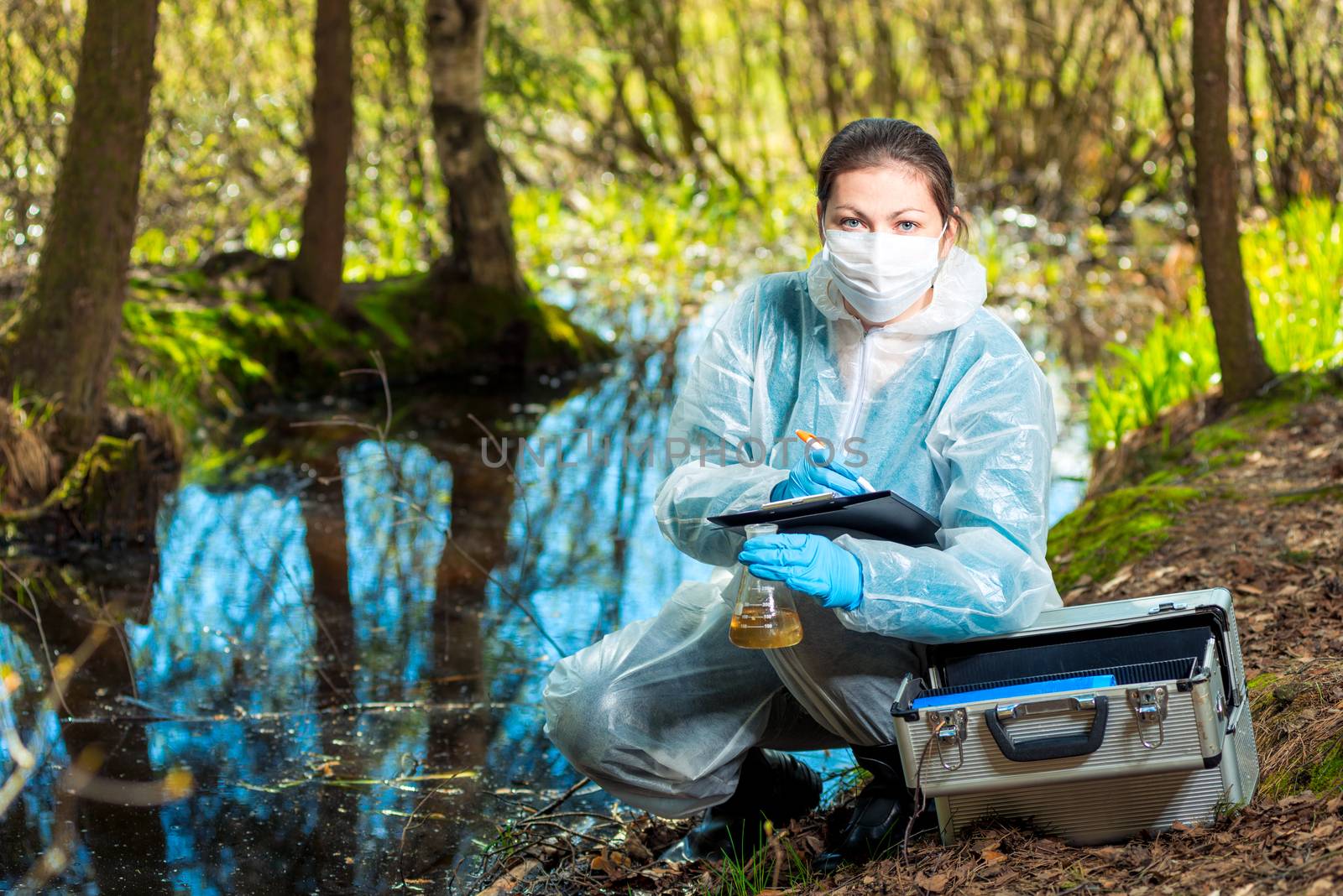 biologist takes water from a forest river to study the composition in the laboratory