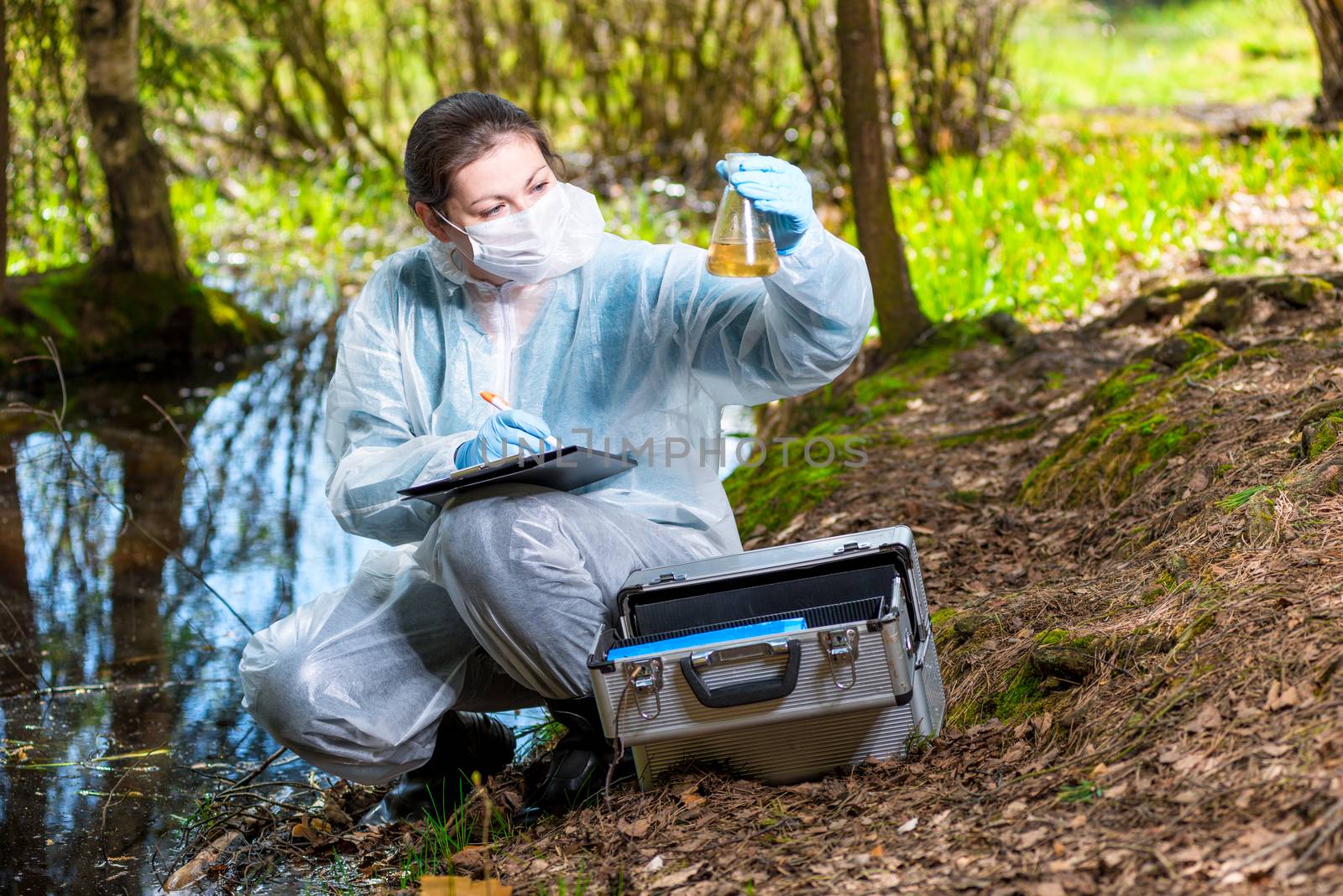 ecologist biologist with a sample of water samples from a forest lake