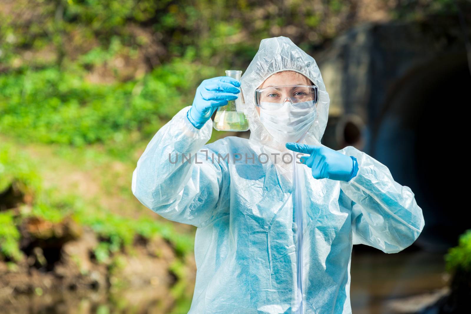 Scientist with a test tube of water in nature by kosmsos111
