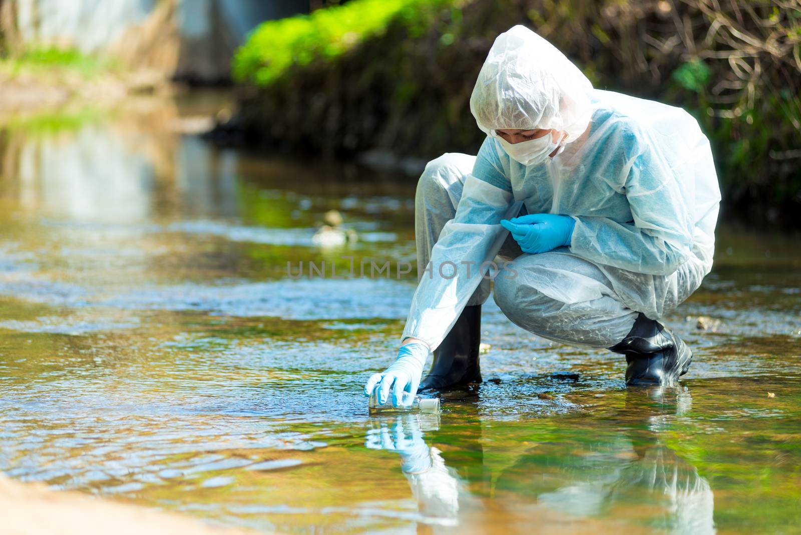 scientist researcher in protective suit takes water for analysis by kosmsos111