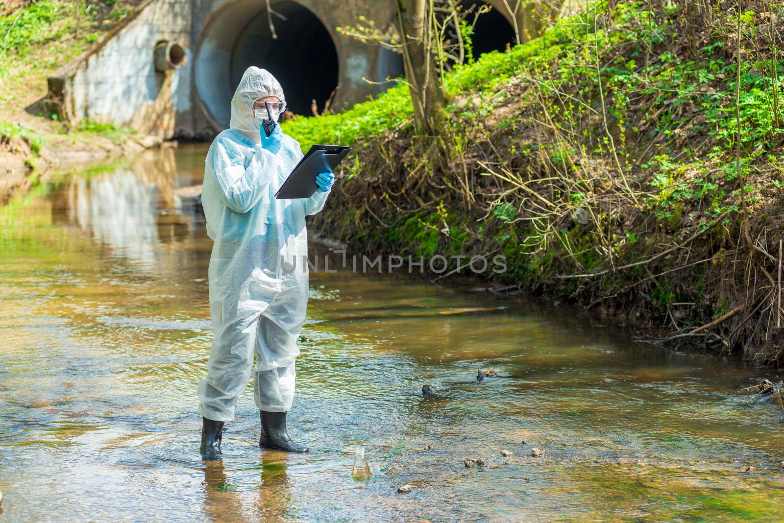 portrait of a scientist in sewer water with a walkie-talkie