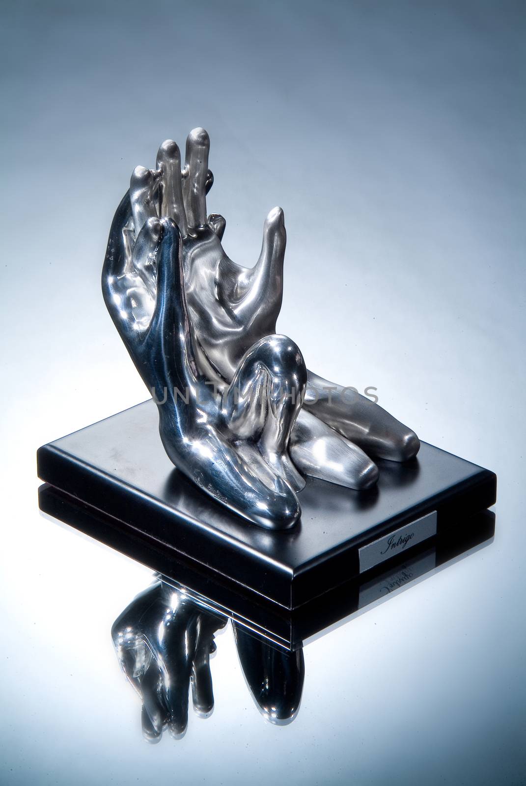 Metal statuettes on a glass studio background