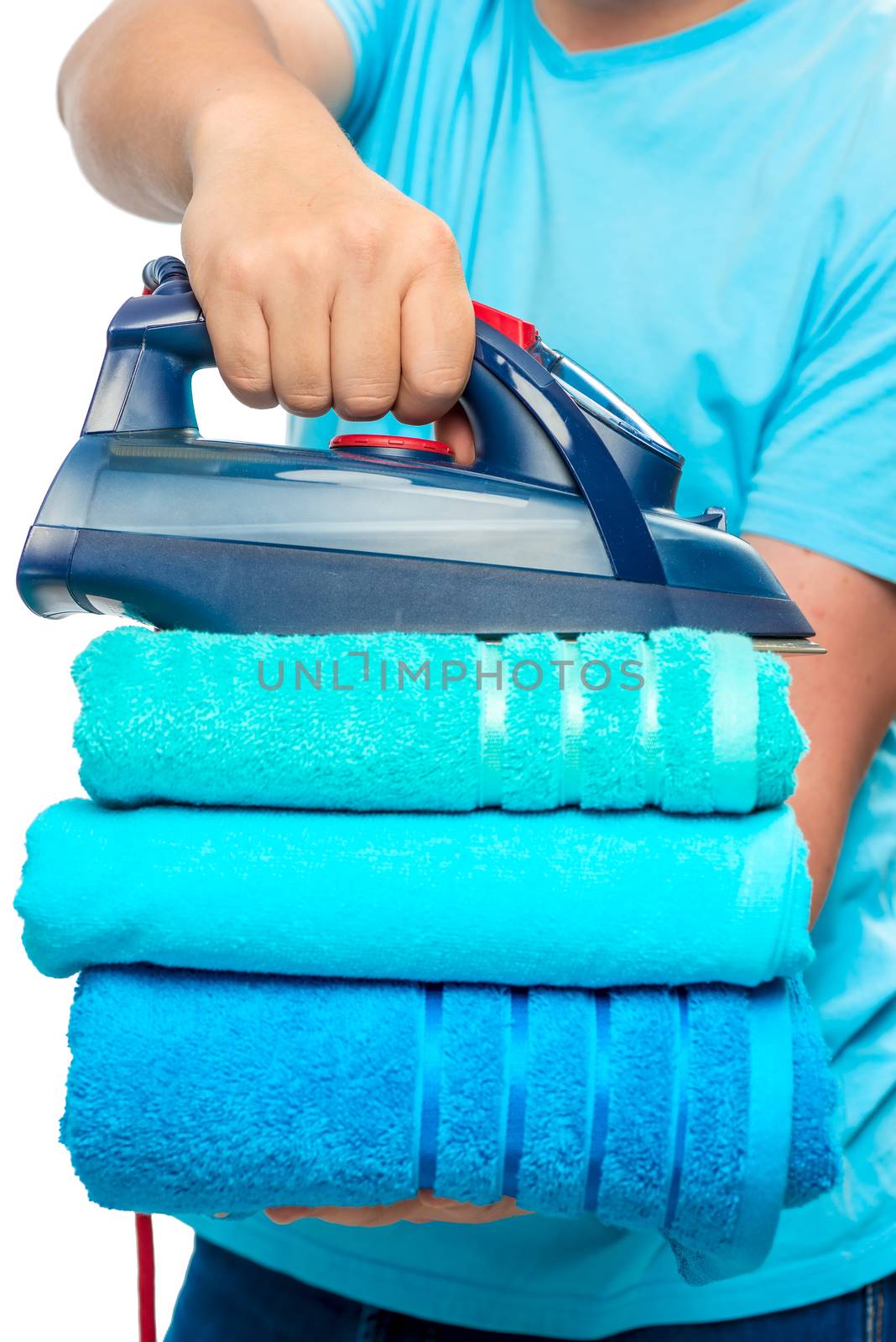 a stack of ironed terry towels and an iron in male hands close-u by kosmsos111