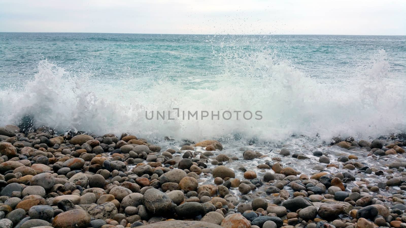 small wave running on the rocky beach.