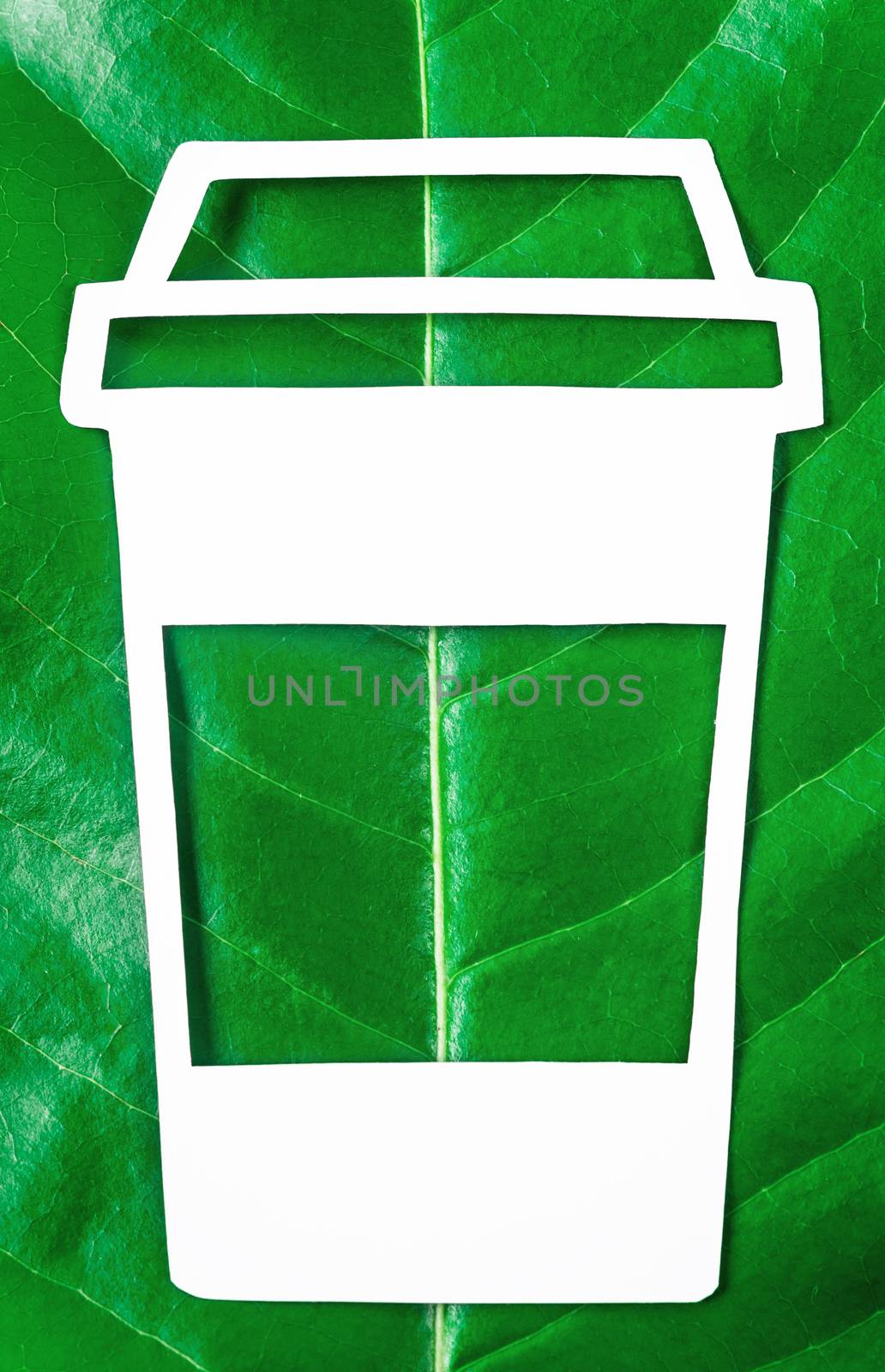 Coffee cup made from paper cut out on leaf green tree. Biodegradable package concept.