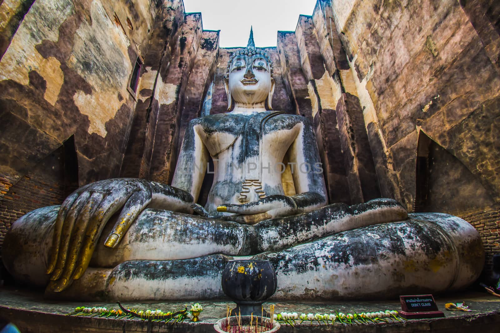 Sukhothai Historical Park, Thailand, traveller with ancient Buddha statue at Wat Si Chum temple. by anuraksir