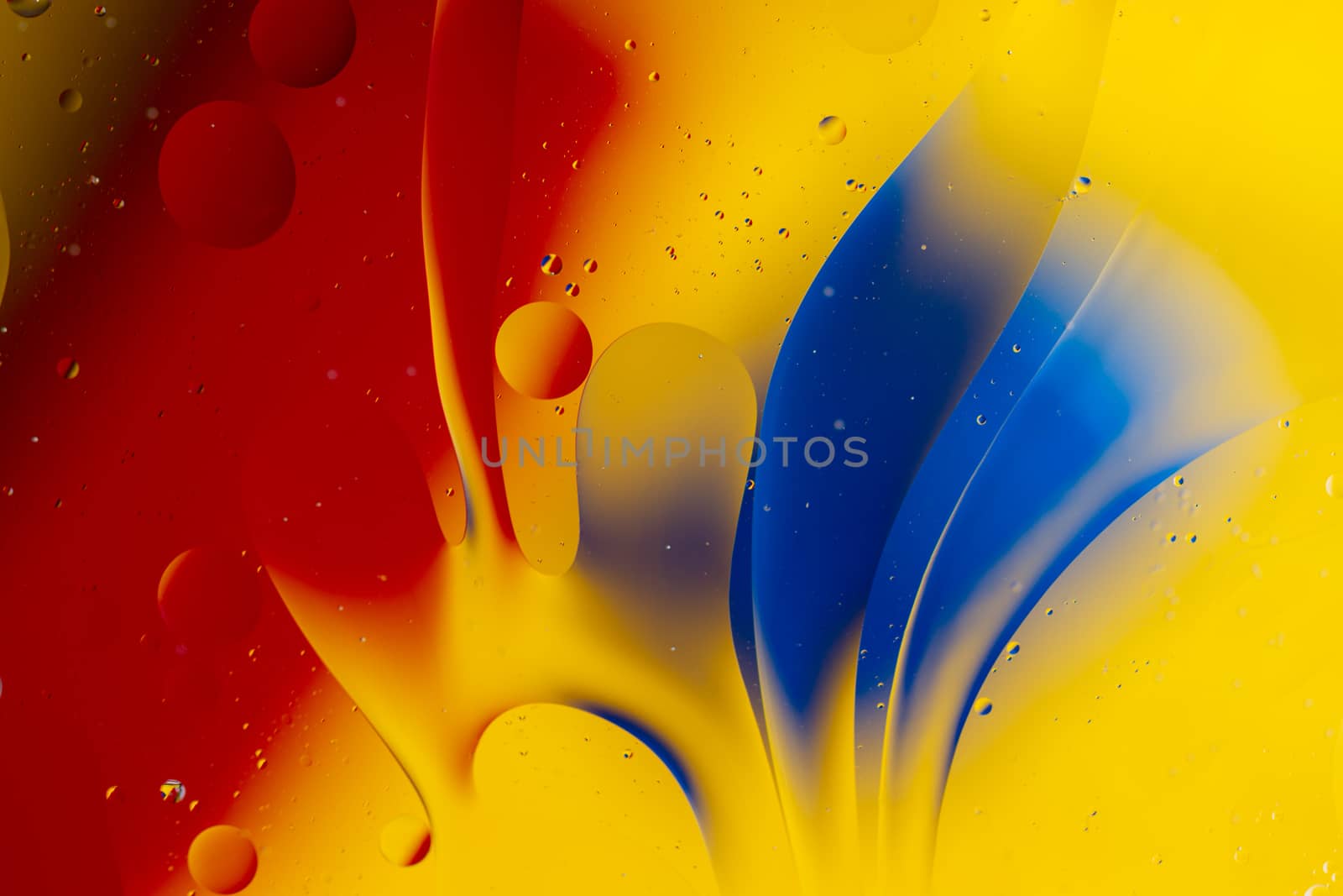 Abstract oil spots in motion on water on blurred yellow backgrou by alexsdriver