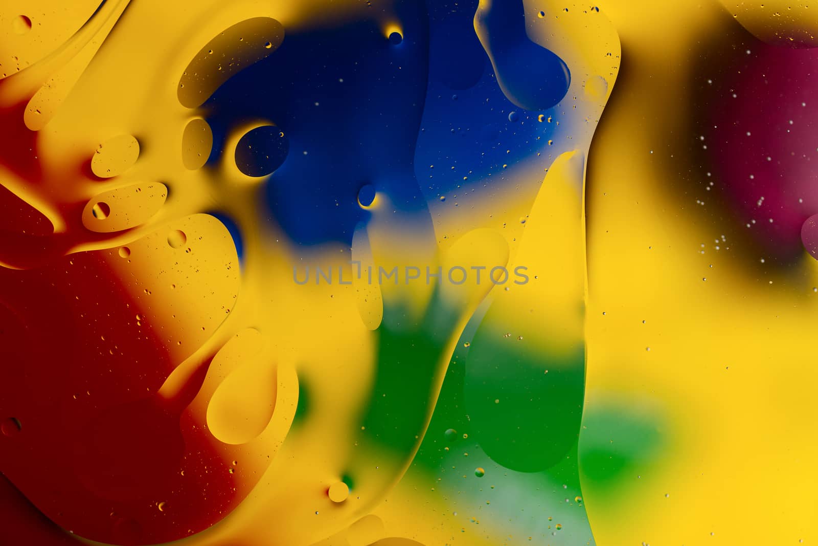 Abstract oil spots in motion on water on blurred yellow backgrou by alexsdriver