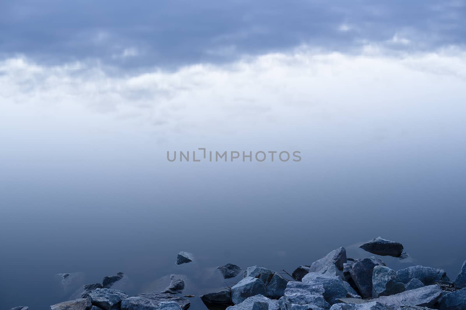 Gray evening sunset above the lake or river. Blue clouds on hori by alexsdriver