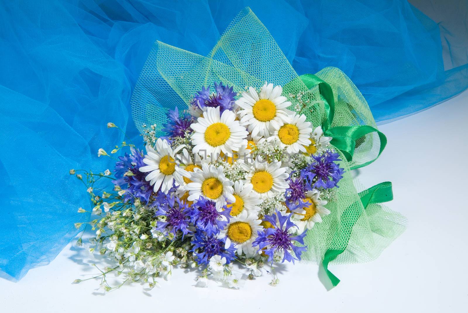 Still life with bouquet of flowers and accessories on a studio background