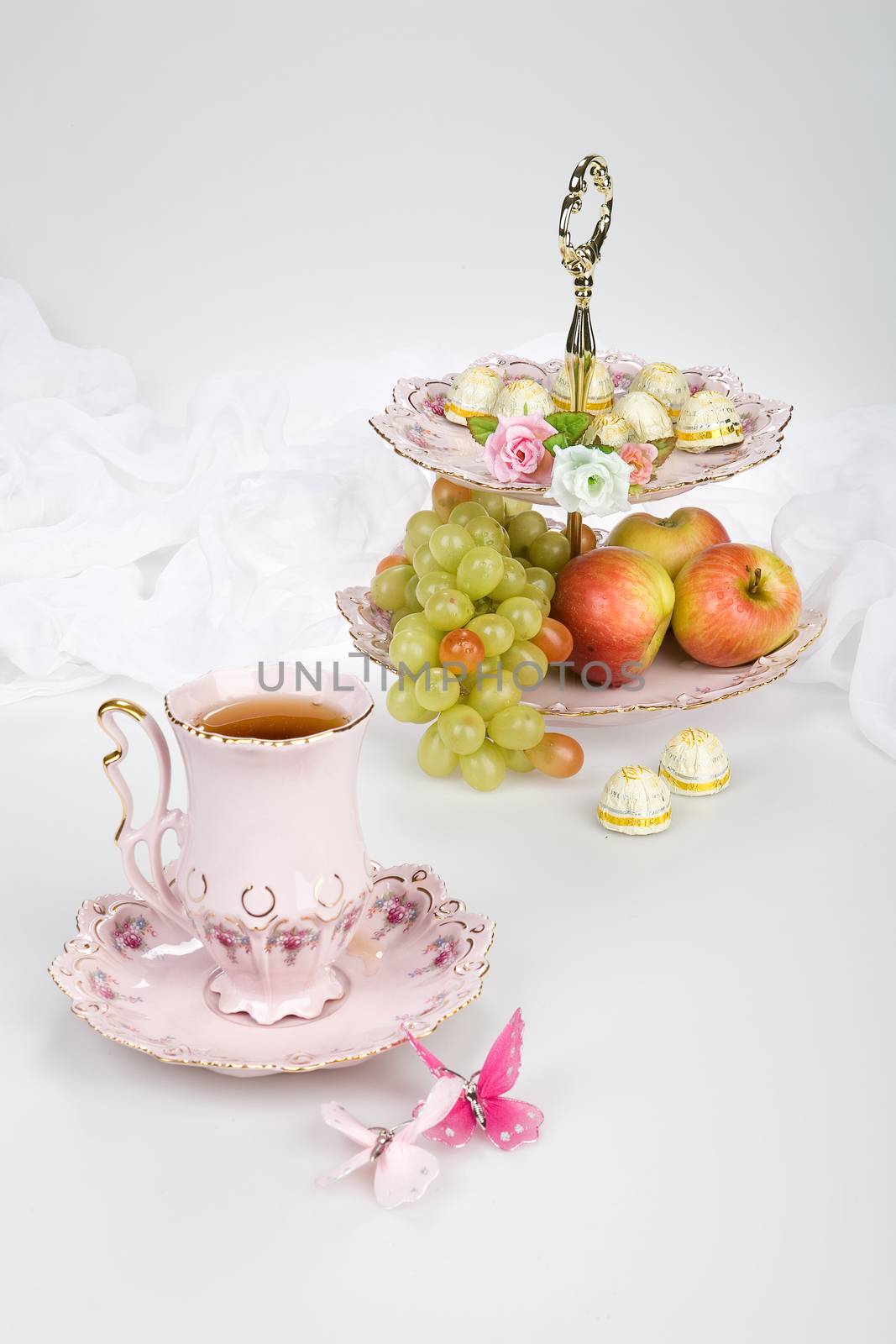 Cup of tea and fruits on a studio background