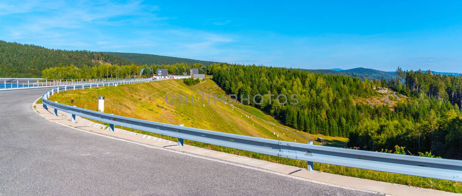 Josefuv Dul Dam, Earth-filled dam in Jizera Mountains with asphalt road on the top, Czech Republic. Sunny summer day.
