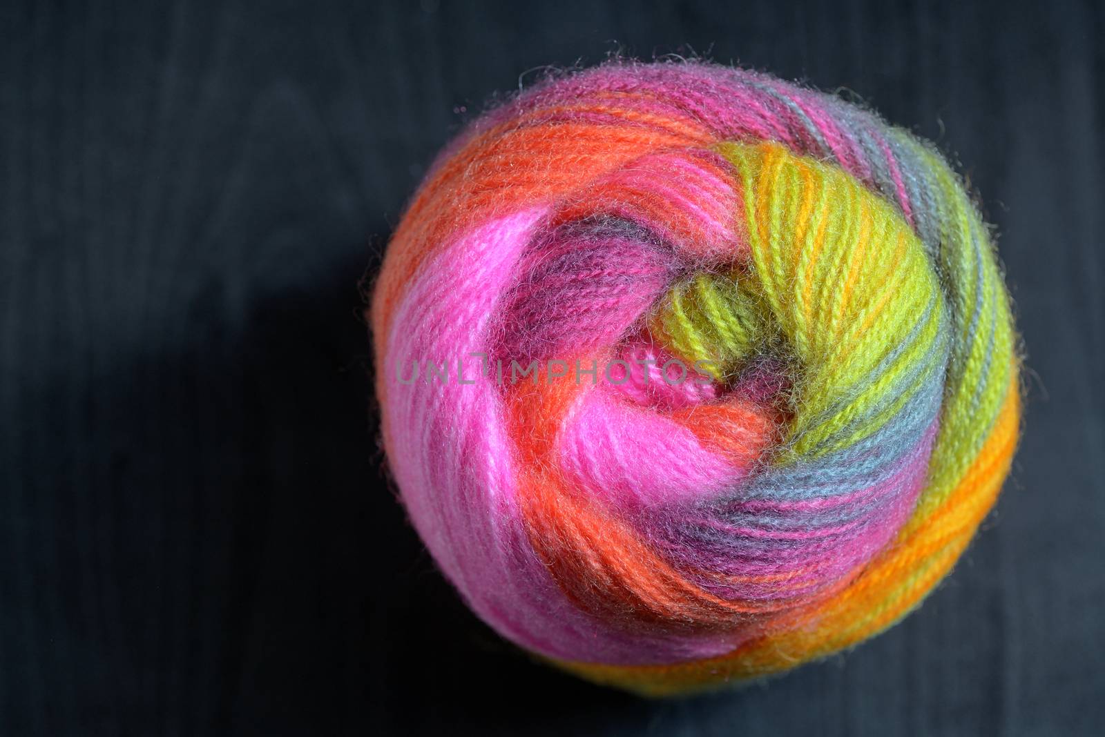 Colorful knitting wool details on black table