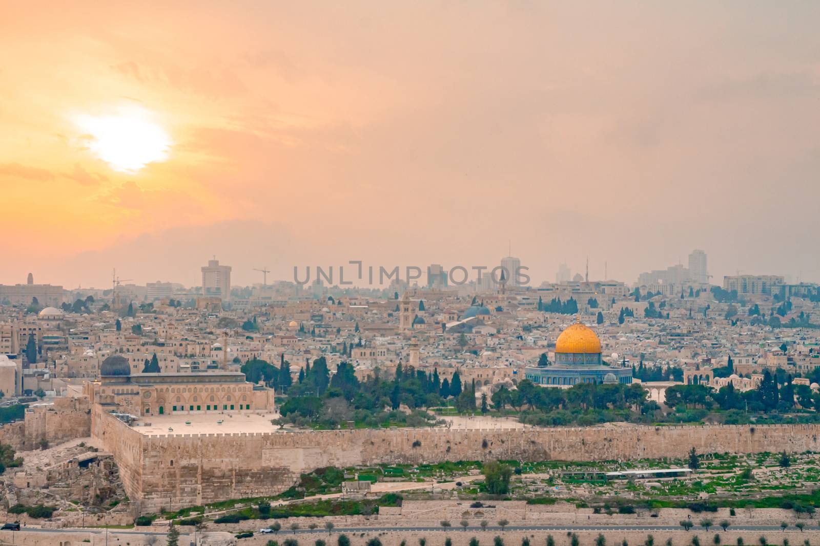 Panoramic view of Jerusalem old city and the Temple Mount during a dramatic colorful sunset. A view of the Dome of the Rock and Al Aqsa Mosque from the Mount of Olives in Jerusalem, Israel.