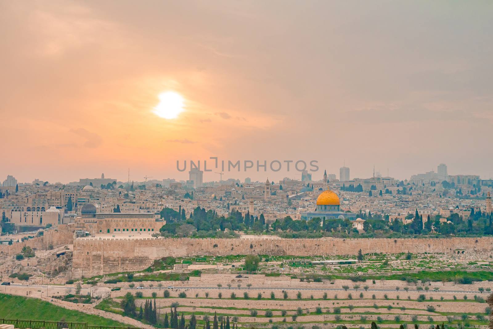 Panoramic view of Jerusalem old city and the Temple Mount during a dramatic colorful sunset. A view of the Dome of the Rock and Al Aqsa Mosque from the Mount of Olives in Jerusalem, Israel.
