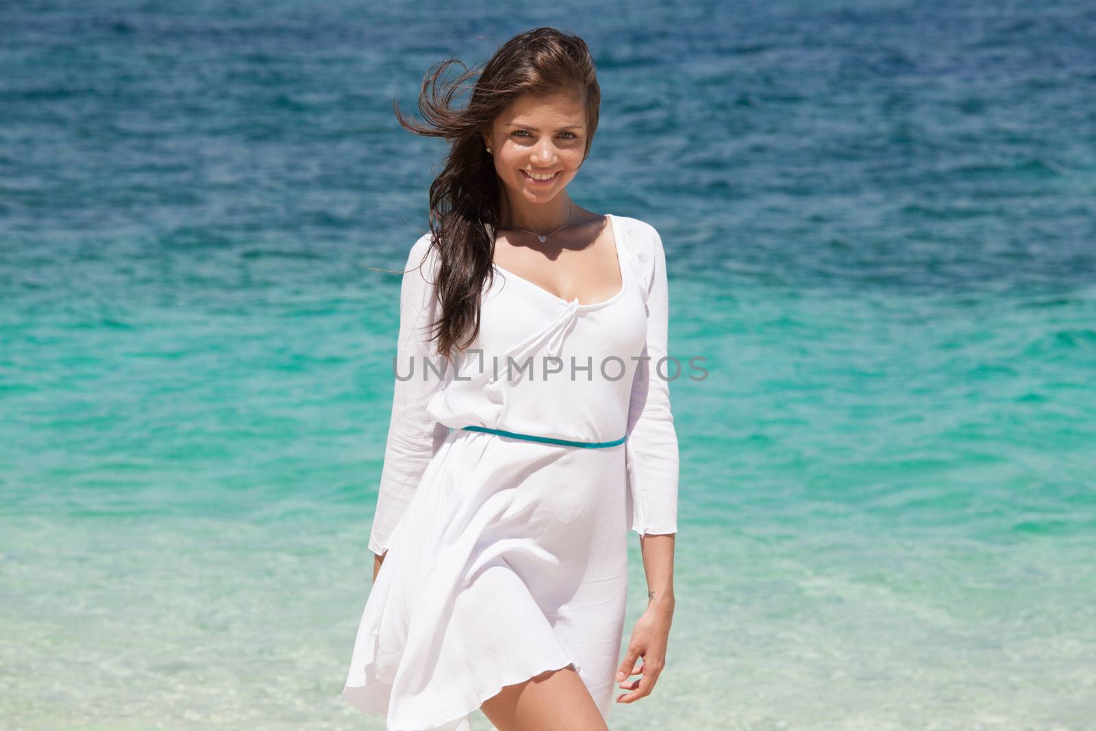 Woman relaxing at the beach enjoying her freedom wear white dress