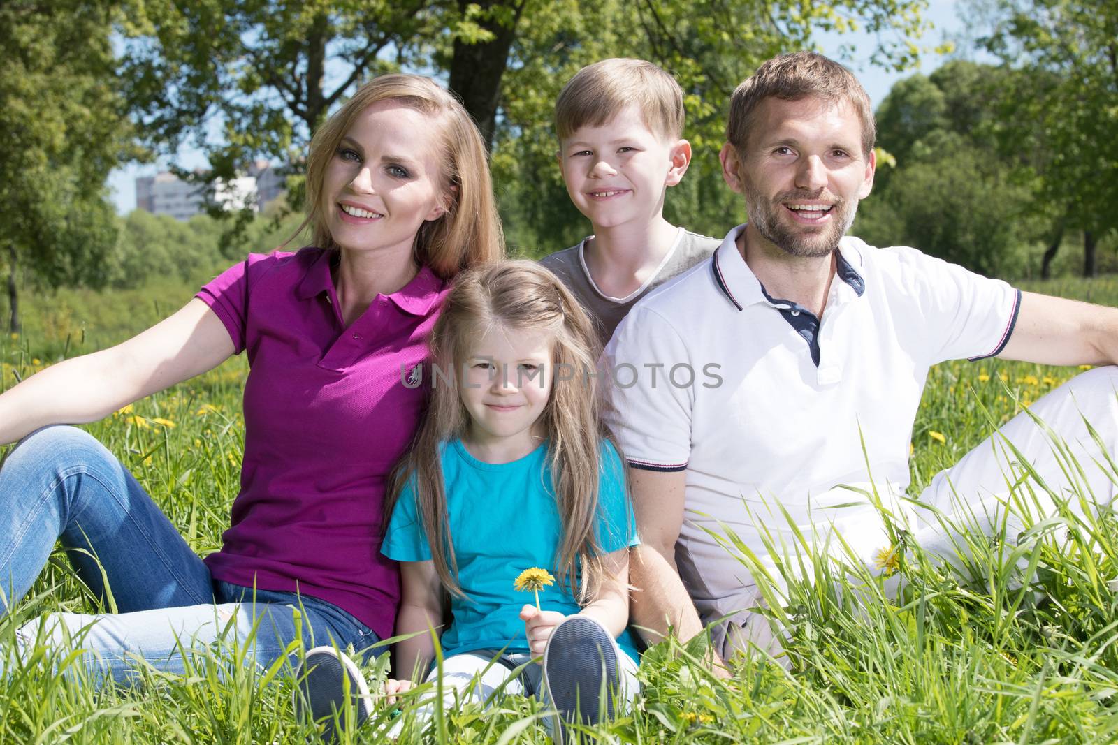 Family on grass in summer park by Yellowj
