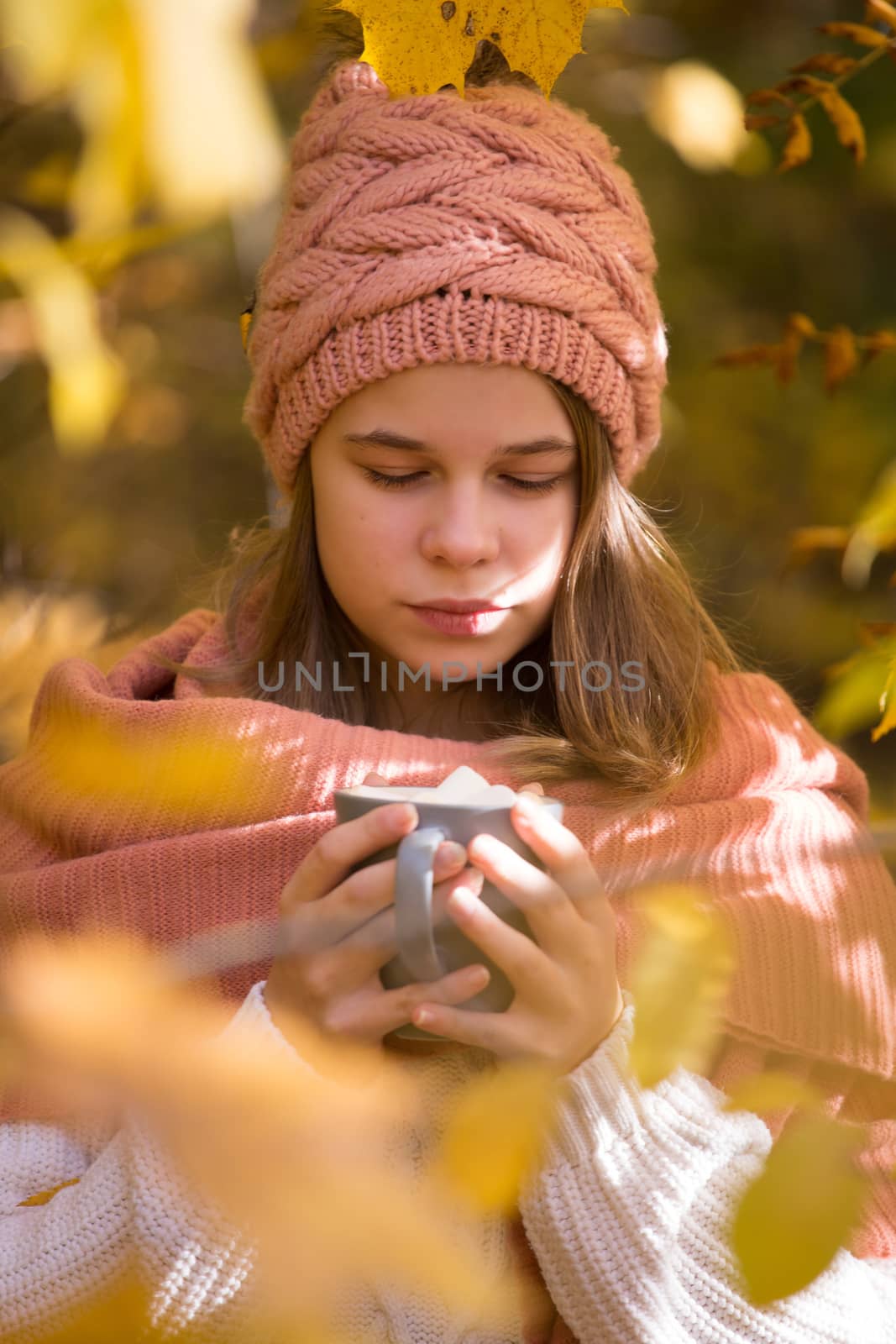 Girl drinking cocoa in autumn park by destillat