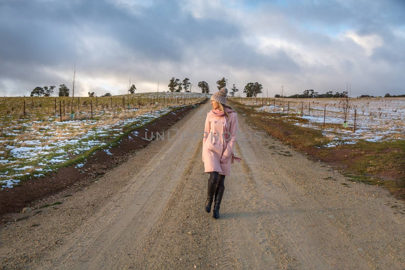 Woman walking down a country road in winter by lovleah