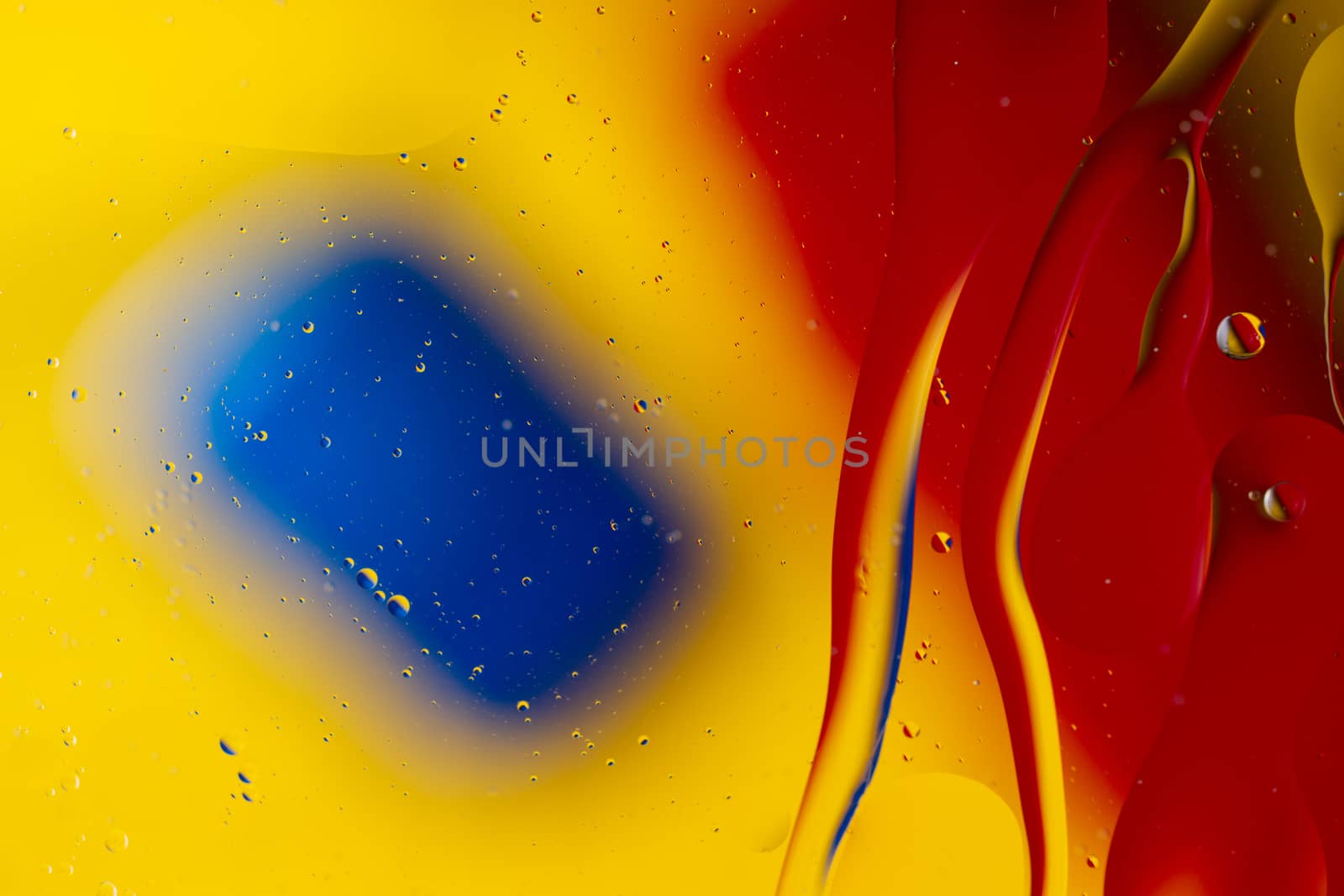 Abstract oil spots in motion on water on blurred yellow backgrou by alexsdriver