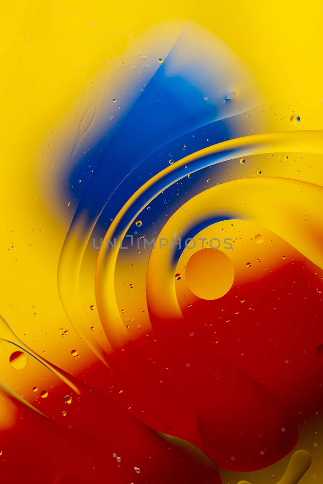 Abstract oil spots in motion on water on blurred yellow backgrou by alexsdriver