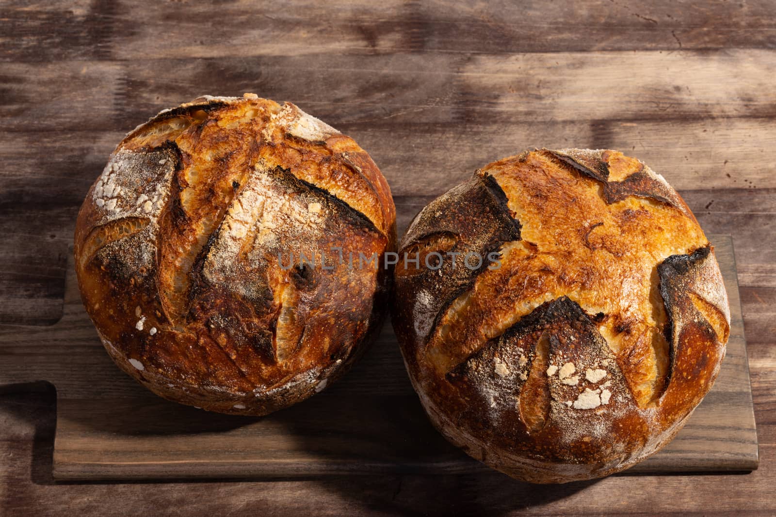 Freshly baked artisan sourdough bread loaves on a wooden board.