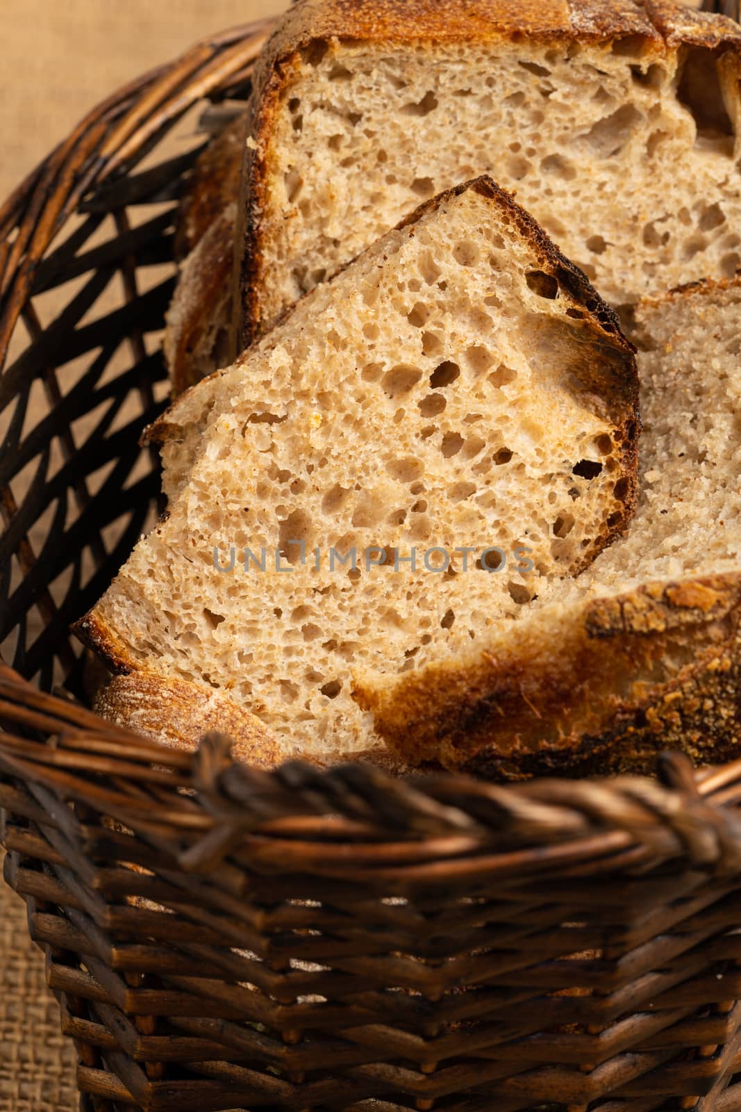 Close up of hearty artisan sourdough bread slices in a bread basket.