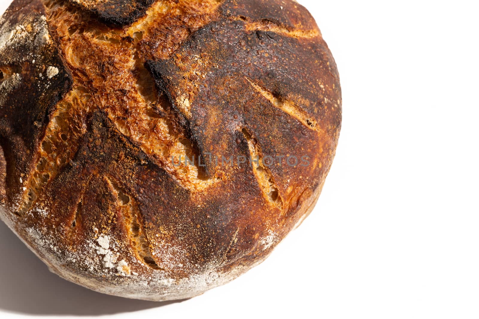 Close up of freshly baked artisan sourdough bread loaf isolated on white.