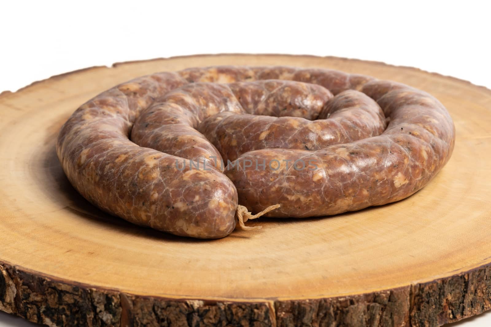 Raw homemade stuffed pork sausages isolated on a woodboard.