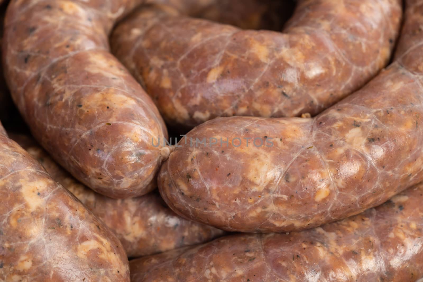 Closeup texture of freshly made raw homemade stuffed pork sausages.