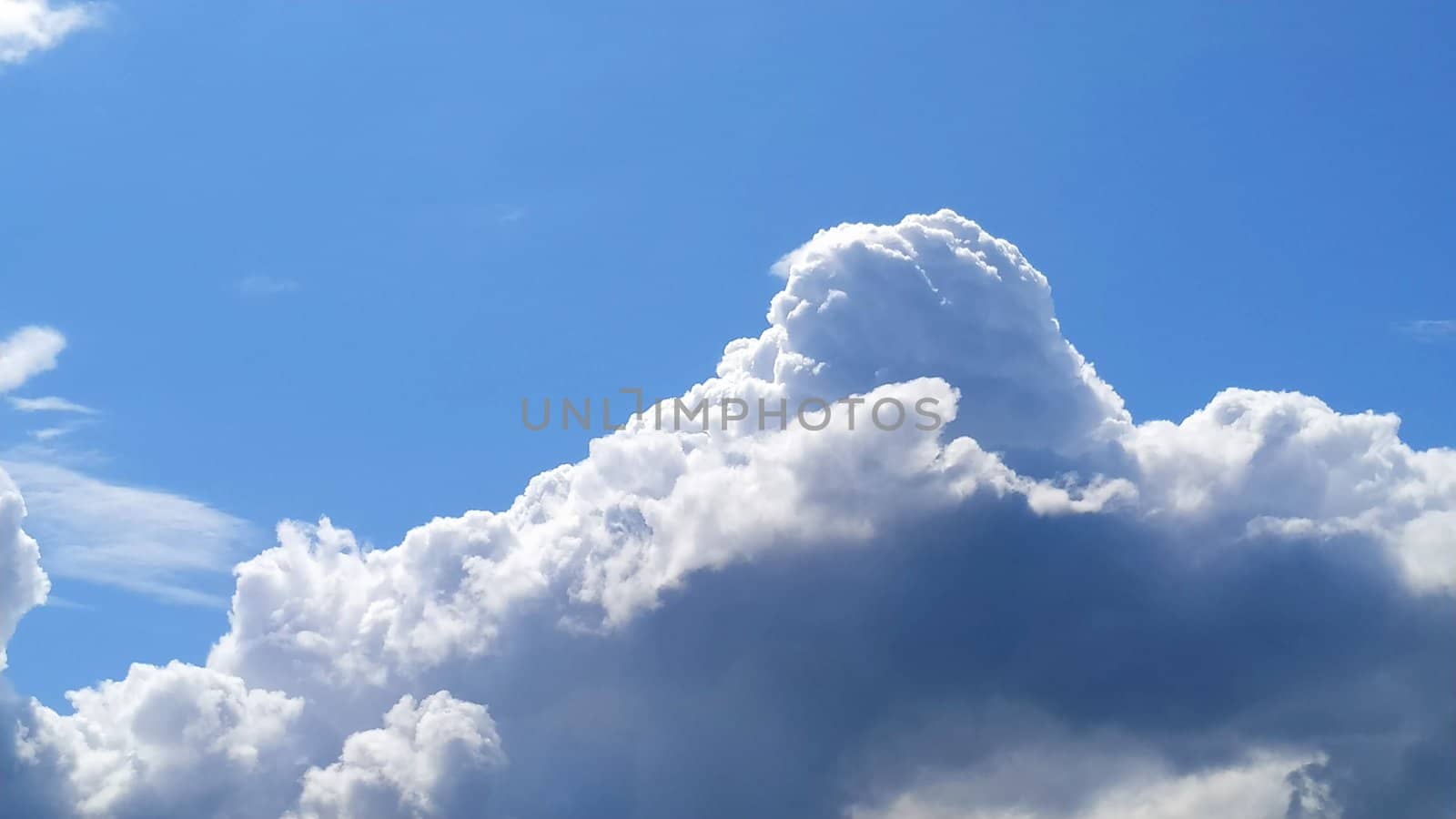 White cumulus clouds against a blue sky.