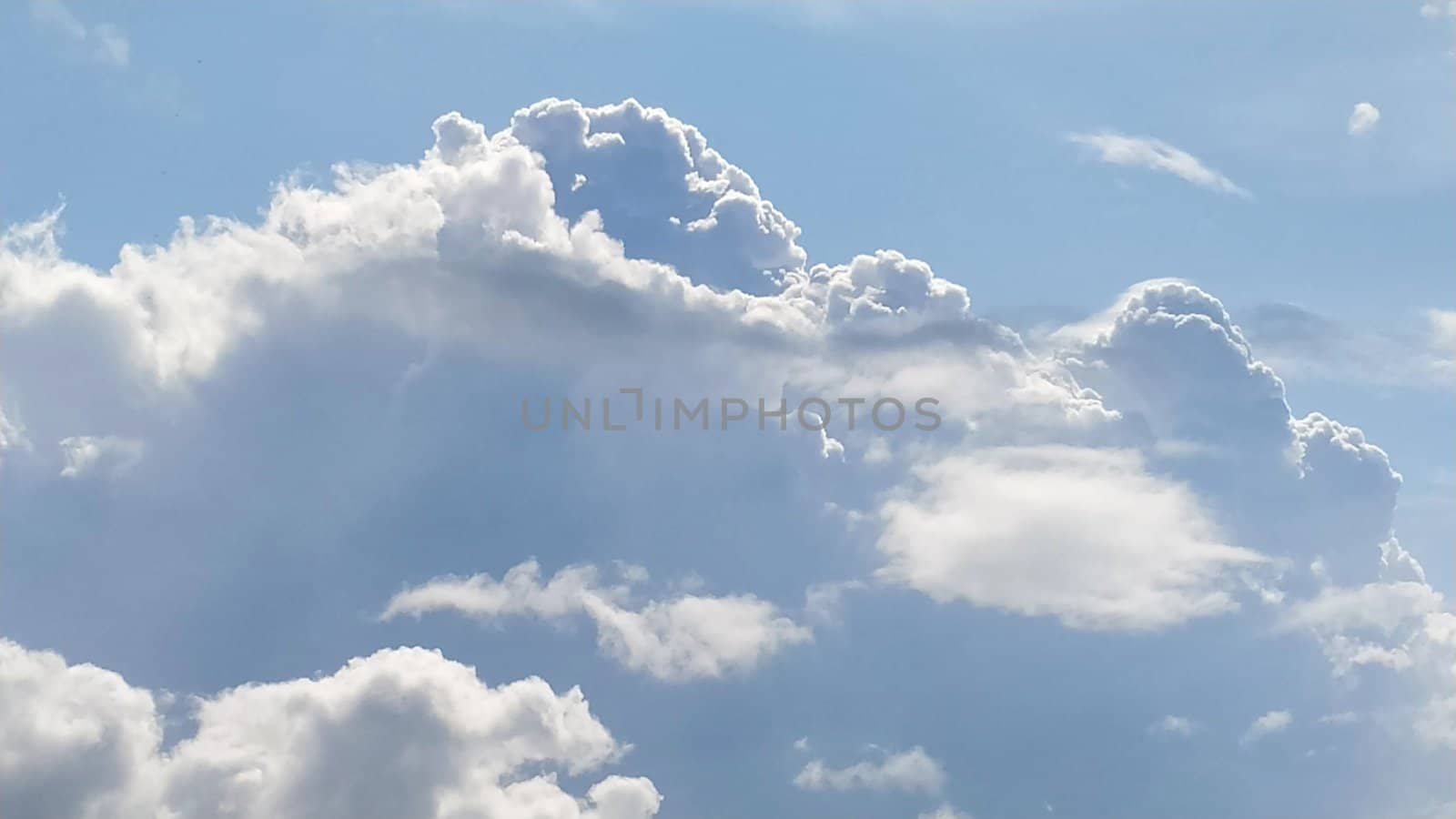 White cumulus clouds against a blue sky.