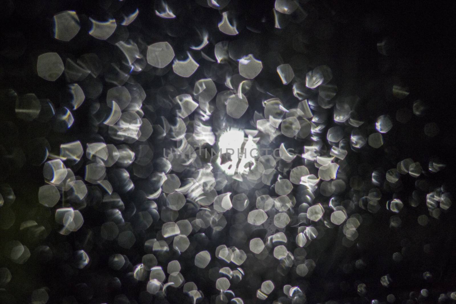 Night blurred rain bokeh backdrop. Rain water on glass and lamp in the dark
