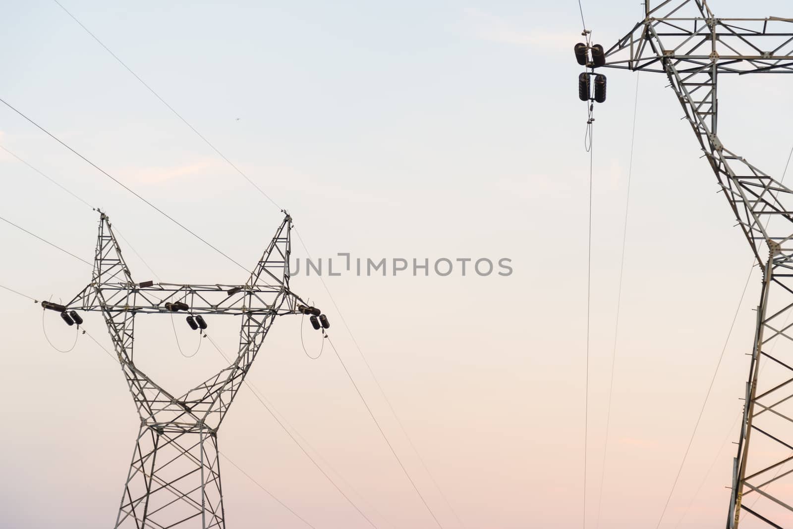 Electricity cable communication towers on sunset.