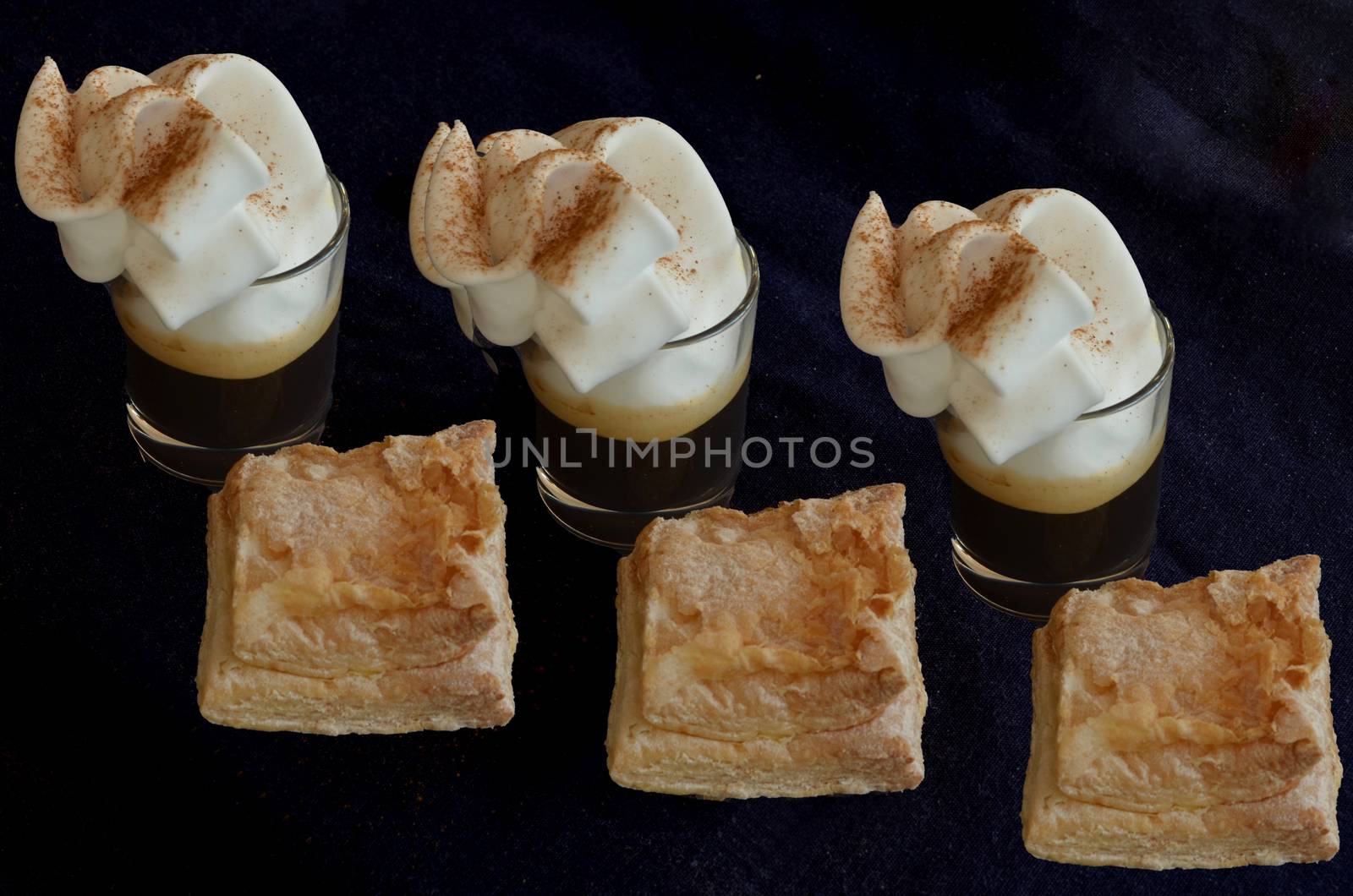 Three cups of coffee with cream and pastries typical of Castilla La Mancha